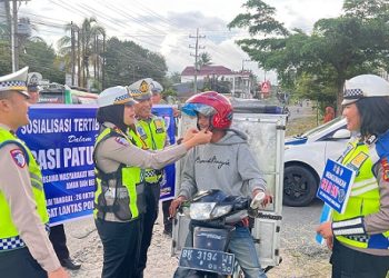 Kasat Lantas AKP Friska Susana SH saat berikan helm kepada pengendara sepedamotor