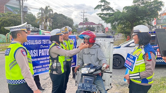 Kasat Lantas AKP Friska Susana SH saat berikan helm kepada pengendara sepedamotor