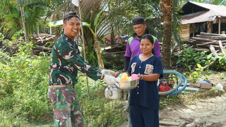 Tampak warga memberikan minuman dan makanan kepada satgas TMMD Imbangan Kodim 1016/Palangka Raya ke-125 bersama warga terlihat sangat akrab, bertempat di Desa Karya Bakti, Kecamatan Rungan, Kabupaten Gunung Mas, minggu (03/08/25).