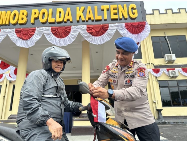 Satuan Brimob Polda Kalimantan Tengah menggelar aksi pembagian ratusan bendera Merah Putih kepada para pengendara yang melintas di depan Mako Satbrimob, Kecamatan Bukit Batu, Kota Palangka Raya, Senin (04/08/2025).