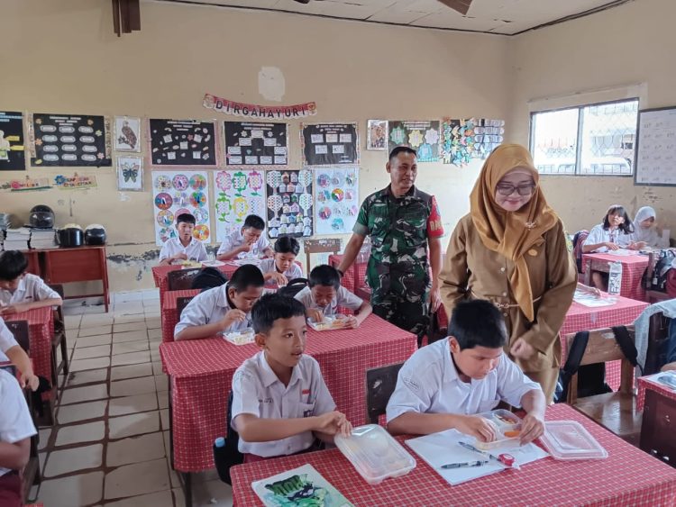 Babinsa 1016 -01/Pahandut Kodim 1016/Palangka Raya Serka Kasan Nudin melaksanakan pendampingan pembagian Makan Bergizi Gratis di SDN 9 Palangka jalan Murai Palangka Raya, Jumat (12/09/2025).