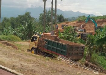 Aktivitas Galian C yang diduga ilegal di wilayah Jonggol, Kabupaten Bogor, terlihat dari deretan truk pengangkut material yang hilir mudik di area tambang, menimbulkan kerusakan jalan serta debu tebal yang dikeluhkan warga sekitar.