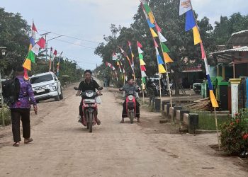 Warga dan kendaraan melintas di jalan poros Kecamatan Air Sugihan, Kabupaten OKI, yang tengah dibangun dan diperbaiki untuk meningkatkan konektivitas antar desa melalui sinergi pemerintah daerah, swasta, dan pemerintah desa.