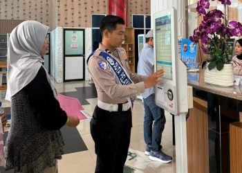 Petugas kepolisian melayani warga yang mengurus administrasi SIM dan dokumen kendaraan di Samsat Cibinong, Kabupaten Bogor, melalui layanan mandiri berbasis digital guna mempercepat proses pelayanan yang tertib, transparan, dan ramah, Selasa (26/11/2025).