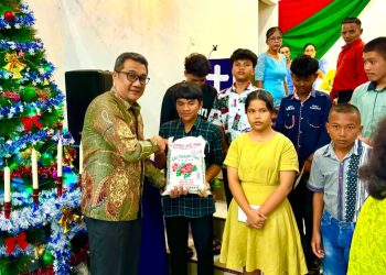 Manajer Kebun Bah Birung Ulu, Yuna Shaund H.S. Damanik, menyerahkan bantuan sembako kepada salah satu anak yatim dalam rangka Perayaan Natal Oikumene Tahun 2025 di Gereja HKBP Kebun Bah Birung Ulu, Jumat (5/12/2025). Penyerahan ini menjadi bagian dari kegiatan sosial PTPN IV Regional II yang turut menghadirkan sukacita dan kepedulian bagi anak-anak yang membutuhkan.