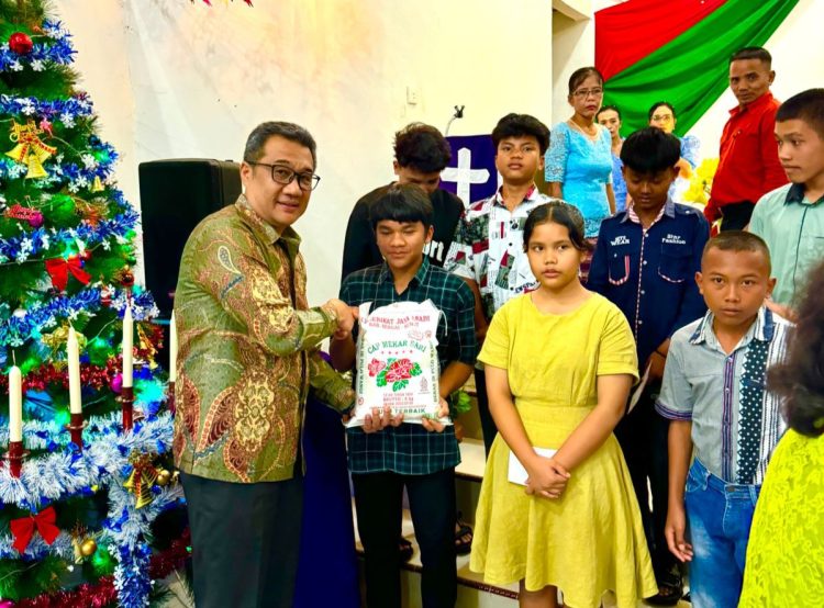 Manajer Kebun Bah Birung Ulu, Yuna Shaund H.S. Damanik, menyerahkan bantuan sembako kepada salah satu anak yatim dalam rangka Perayaan Natal Oikumene Tahun 2025 di Gereja HKBP Kebun Bah Birung Ulu, Jumat (5/12/2025). Penyerahan ini menjadi bagian dari kegiatan sosial PTPN IV Regional II yang turut menghadirkan sukacita dan kepedulian bagi anak-anak yang membutuhkan.