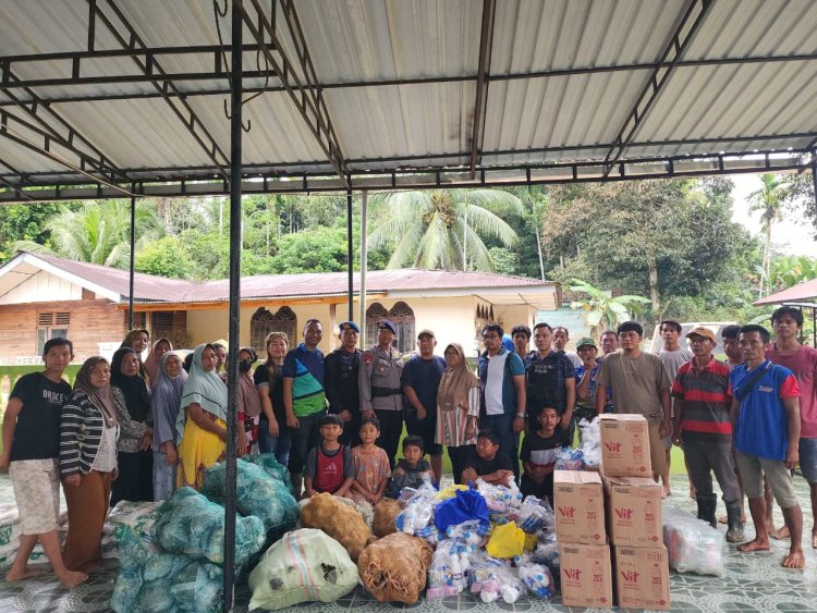 Sejumlah warga bersama relawan dan aparat setempat berfoto bersama saat proses penyerahan bantuan kemanusiaan untuk korban banjir di Aceh Tamiang. Beragam paket sembako, sayuran, air minum kemasan, serta kebutuhan dasar lainnya tampak tersusun di lokasi sebelum didistribusikan kepada masyarakat terdampak.