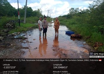 Personel Polsek Indralaya melakukan pengecekan langsung ke lokasi banjir yang terjadi di Desa Tanjung Pule, Kecamatan Indralaya Utara, Kabupaten Ogan Ilir, Senin (15/12/2025).