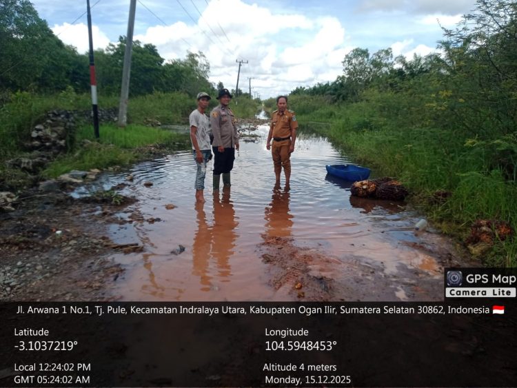 Personel Polsek Indralaya melakukan pengecekan langsung ke lokasi banjir yang terjadi di Desa Tanjung Pule, Kecamatan Indralaya Utara, Kabupaten Ogan Ilir, Senin (15/12/2025).