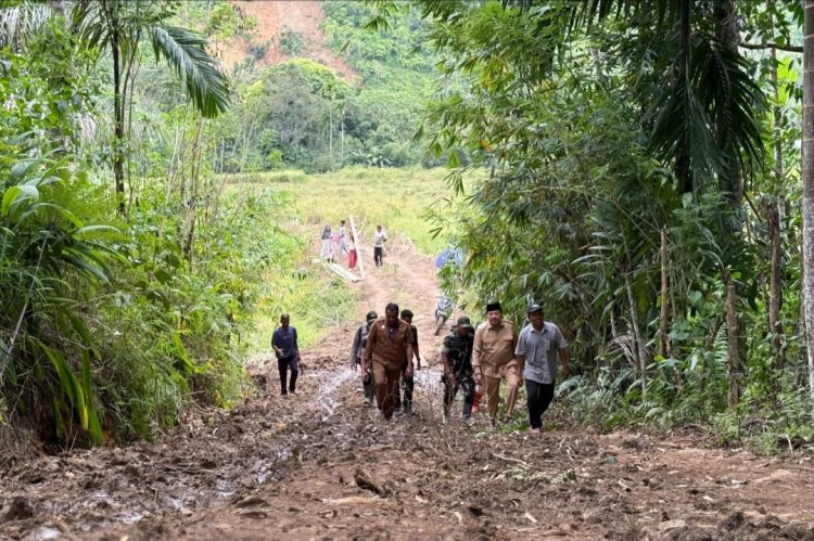Bupati Nagan Raya, Provinsi Aceh, Dr. TR. Keumangan, S.H., M.H., yang akrab disapa TRK, menelusuri jalan setapak sejauh hampir empat hingga lima kilometer dengan berjalan kaki untuk mencapai kawasan permukiman warga yang luluh lantak akibat banjir bandang di Kecamatan Beutong Ateuh Banggalang, Selasa (9/12/2025).