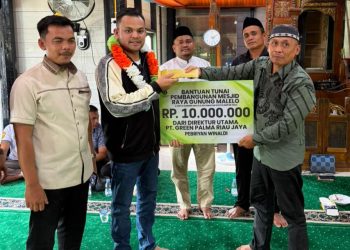 Direktur PT Green Palma Riau Jaya, Pebriyan Winaldi (tengah, mengenakan kalung bunga), menyerahkan bantuan dana sebesar Rp10 juta untuk pembangunan dan pemeliharaan Masjid Raya Gunung Malelo, Desa Gunung Malelo, Kecamatan Koto Kampar Hulu.
