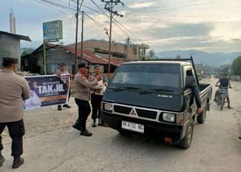 personel Polsek Parongil melaksanakan kegiatan berbagi takjil kepada para pengguna jalan yang melintas di depan Mako Polsek Parongil, Selasa (24/2/2026).