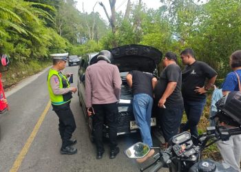 Personel Pos Pengamanan (Pos Pam) Simpang 3 Tele, Kecamatan Harian, Kabupaten Samosir, menunjukkan kesigapan dan kepedulian terhadap masyarakat/wisatawan dengan membantu sebuah mobil yang mengalami mogok di jalur perbukitan Tele, Jumat (20/03/2026) sekitar pukul 11.30 WIB.