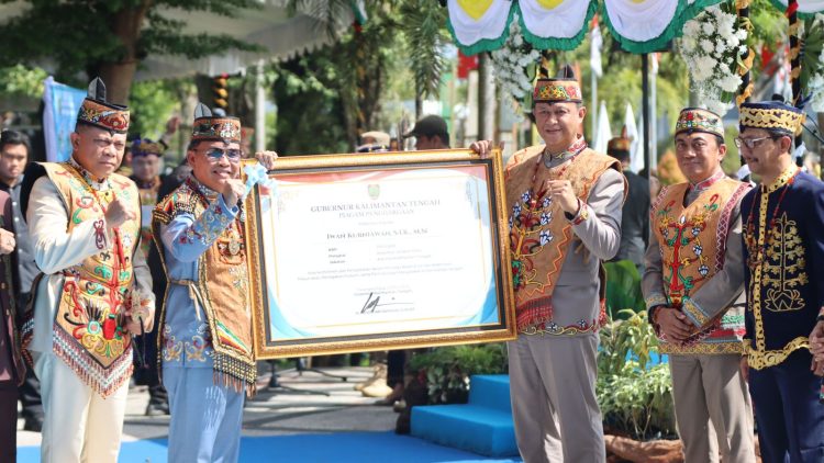 Gubernur Kalteng H. Agustiar Sabran menyerahkan langsung penghargaan kepada Kapolda Kalteng, Irjen Pol Iwan Kurniawan, usai pelaksanaan upacara HUT Kalteng ke-69, di Halaman Kantor Gubernur, Sabtu (23/5/2026).