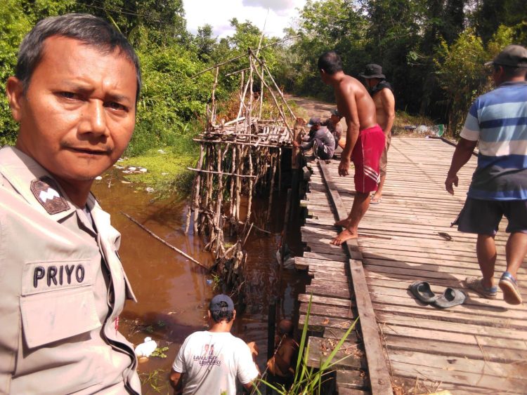 Bhabinkamtibmas Kelurahan Marang Polsek Bukit Batu melaksanakan sambang kamtibmas dengan menyambangi warga yang sedang melakukan perbaikan jembatan di wilayah Kelurahan Marang.