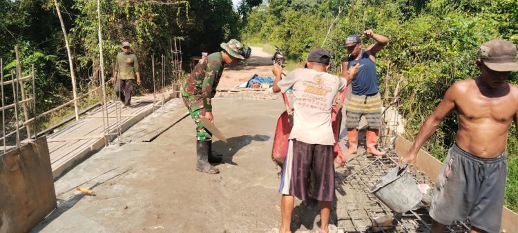 , Serka Agus Sunarto Babinsa Koramil 1016-02/Bukit Batu, Kodim 1016/Palangka Raya bersama warga Kelurahan Marang Kecamatan Bukit Batu, Kota Palangka Raya Senin (20/7/2026) melaksanakan gotong royong melanjutkan pembangunan jembatan Armco.