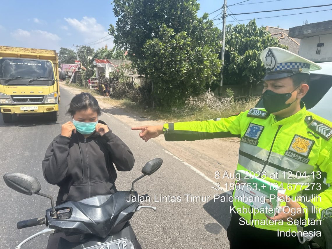 personel Polres Ogan Ilir membagikan masker kepada pengendara dan masyarakat yang berada di sekitar lokasi kebakaran di Desa Pulau Semambu, Kecamatan Indralaya Utara, Kabupaten Ogan Ilir, Sabtu (8/8/2026).