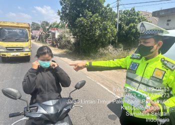 personel Polres Ogan Ilir membagikan masker kepada pengendara dan masyarakat yang berada di sekitar lokasi kebakaran di Desa Pulau Semambu, Kecamatan Indralaya Utara, Kabupaten Ogan Ilir, Sabtu (8/8/2026).
