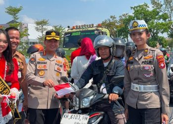 Polda Kalimantan Tengah membagikan bendera Merah Putih kepada pengendara di Bundaran Besar Talawang Kota Palangka Raya untuk menyambut HUT ke-81 Kemerdekaan Republik Indonesia, Senin (10/8/2026).