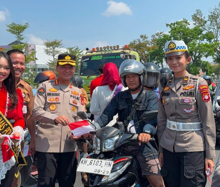 Polda Kalimantan Tengah membagikan bendera Merah Putih kepada pengendara di Bundaran Besar Talawang Kota Palangka Raya untuk menyambut HUT ke-81 Kemerdekaan Republik Indonesia, Senin (10/8/2026).