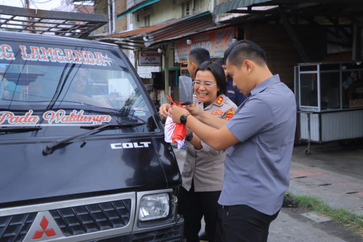 Polres Samosir membagikan sekaligus memasangkan 300 lembar Bendera Merah Putih pada kendaraan masyarakat, Jumat (14/8/2026).
