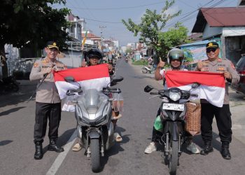 Kapolres Seruyan AKBP Beddy Suwendi, S.H., S.I.K. bersama jajaran membagikan 100 lembar Bendera Merah Putih kepada masyarakat di Kota Kuala Pembuang, Kabupaten Seruyan, Jumat (14/8/2026).