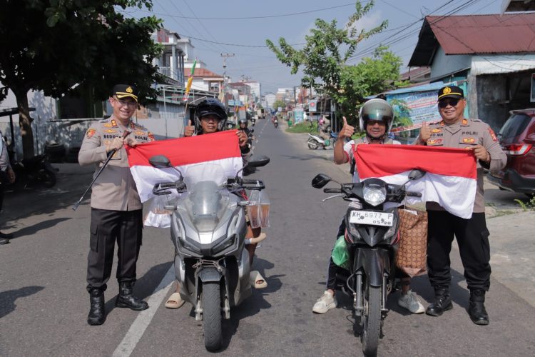 Kapolres Seruyan AKBP Beddy Suwendi, S.H., S.I.K. bersama jajaran membagikan 100 lembar Bendera Merah Putih kepada masyarakat di Kota Kuala Pembuang, Kabupaten Seruyan, Jumat (14/8/2026).