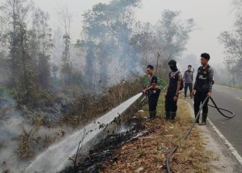 tengah kepulan asap karhutla personel Polda Kalteng terus berjibaku melakukan pemadaman dan pendinginan lahan gambut yang terbakar di kawasan Jl. Mahir Mahar Lingkar Luar,