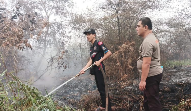 Satgas Tanggap Darurat Karhutla Polresta Palangka Raya Regu I dan Regu 3 melakukan pendinginan serta pembasahan lahan di Jalan Nagasari, Kelurahan Bukit Tunggal,