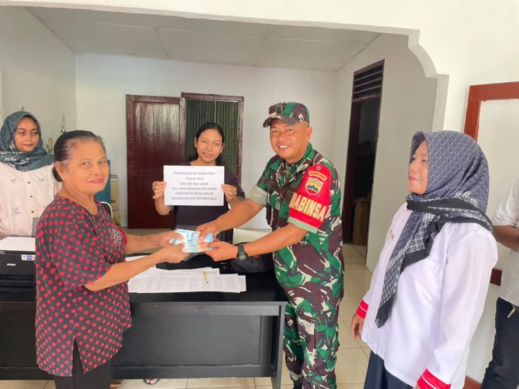 Babinsa Koramil 10/Tanah Jawa, Serka Suhadi, bersama Bhabinkamtibmas Aiptu R. Sinurat, melaksanakan pendampingan penyaluran BLT-DD Tahap I Tahun 2026 kepada warga Nagori Bah Jambi, Kecamatan Jawa Maraja Bah Jambi, Kabupaten Simalungun, Rabu (14/10/2026).