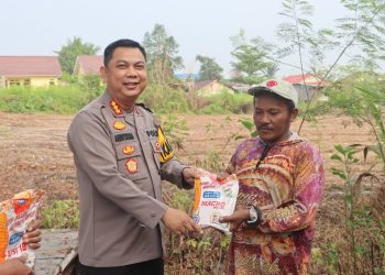 Kapolresta Palangka Raya Kombes Pol Andiyatna, S.I.K., M.H. menyerahkan bibit jagung kepada kelompok tani