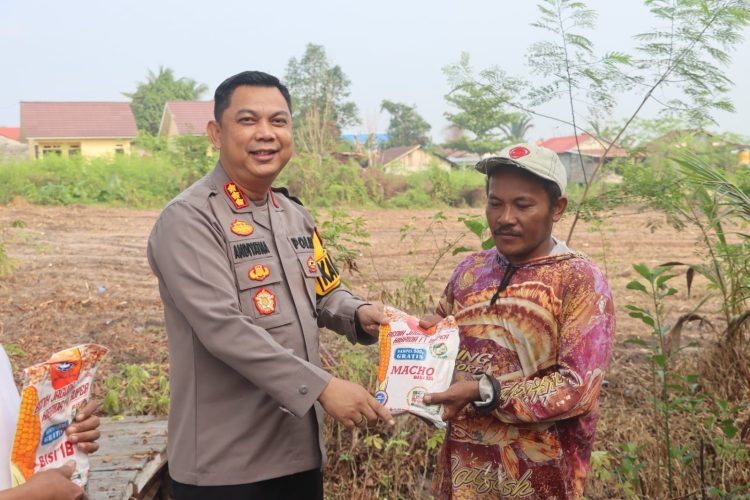 Kapolresta Palangka Raya Kombes Pol Andiyatna, S.I.K., M.H. menyerahkan bibit jagung kepada kelompok tani