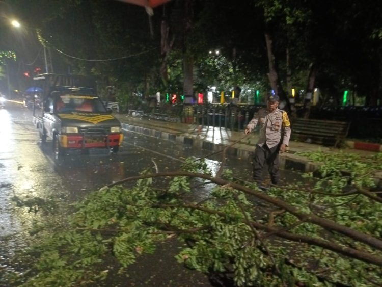 Personil Polsek Siantar Barat Respon Cepat Bersihkan Ranting Pohon yang Menutupi Badan Jalan Merdeka