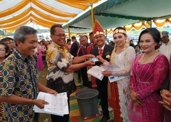 Sekda Pakpak Bharat Serahkan Dokumen Kependudukan Bagi Pengantin Baru di Kecamatan Tinada