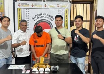 JP tertunduk diapit petugas Satuan Narkoba (Dok Polres Simalungun)