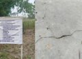 Plang proyek dan rabat beton dengan kondisi retak memanjang