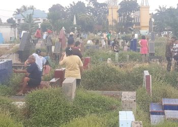 Pulang Ibadah, Umat Kristen Ziarah Ke Makam Orang Tua.
