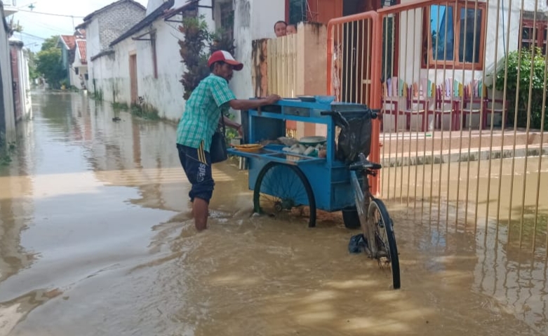Demi Menafkahi Keluarga, Seorang Pedagang Sate Keliling Tetap Berjualan di Tengah Banjir